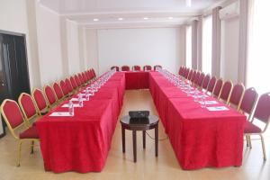 a long table with red tables and chairs in a room at Star Hotel in Bishkek