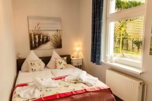 a bedroom with a bed with towels on it at Villa Morgentau in Zinnowitz