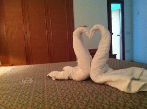 two towels shaped like swans laying on a bed at Hotel Eden in San Domino