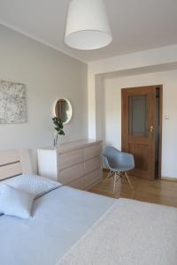 a bedroom with two beds and a blue chair at Apartament Barlinek in Barlinek