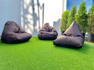 three bean bag chairs sitting on the grass at Stay Inn Hostel Jakarta in Jakarta