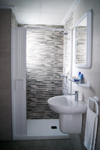 a white bathroom with a sink and a shower at Apartamentos Riviera Beach in Pilar de la Horadada