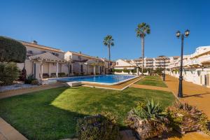 a courtyard with a swimming pool and palm trees at PENTHOUSE CABO ROIG - ALDEAS I in Orihuela Costa