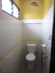 a bathroom with a toilet and a window at Malinja Home in Pantai Cenang