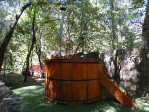 un tonneau en bois dans un parc avec une clôture et des arbres dans l'établissement Cabañas Alegria Cajón del Maipo, à San José de Maipo