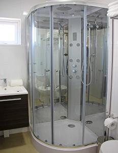 uma casa de banho com um chuveiro e um lavatório. em Departamentos Nómades del Lago em Puerto Varas