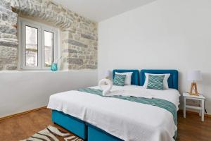a blue and white bed in a room with a window at La Rocca Apartment Old Town Kotor in Kotor