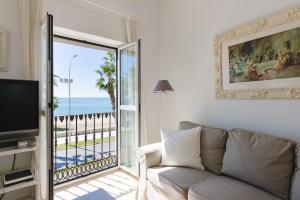 マラガにあるApartamento con encanto en primera linea de playaのリビングルーム(ソファ付)が備わり、海の景色を望めます。