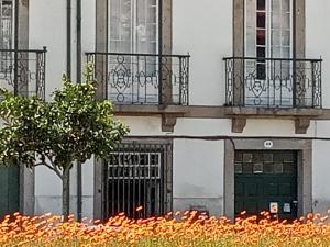 un edificio con 2 balcones y una puerta verde en Dans L'Atelier Hostel en Braga