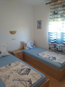 a room with two beds and a window at Holiday S&M in Lopar