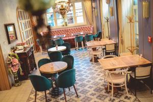 a restaurant with tables and chairs in a room at Boutique Macchiato House in Novi Sad