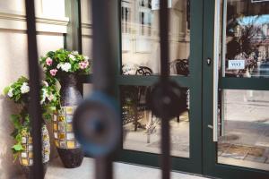 Una ventana con dos jarrones con flores. en Boutique Macchiato House, en Novi Sad