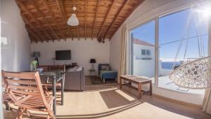 un soggiorno con tavolo e sedie e una grande finestra di Água de Alto Terrace House a Água de Alto