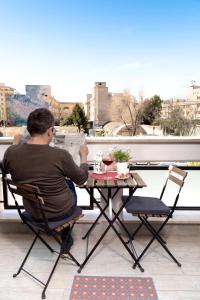 un uomo seduto a un tavolo su un balcone di B&B Easy a Roma