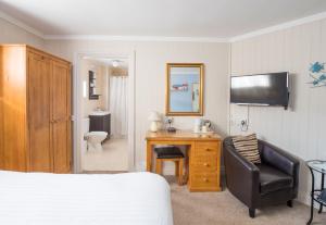 a bedroom with a bed and a desk and a chair at The Grafton Guest House in Llandudno