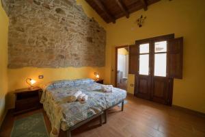 a bedroom with a bed and a stone wall at Arroccas de is Istellas in Arbus