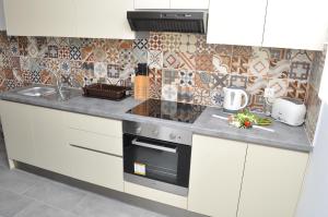 a kitchen with white cabinets and a stove top oven at Polymnia Apartments Lassi in Lassi