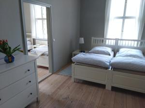 a bedroom with two beds and a mirror at Marstall im Schlosspark Rheinsberg in Rheinsberg