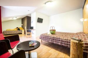 a living room with a bed and a couch at Village club de Bois d'Amont in Bois-dʼAmont