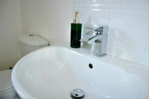 a white bathroom sink with a candle on it at Empire Serviced Apartments in Hinckley