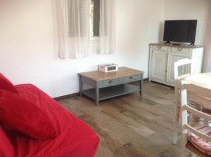 a living room with a red couch and a table at 1262 Chemin des Pignatelles in La Motte