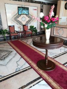 a lobby with a table with flowers on it at Leen Serviced Apartments in Jeddah