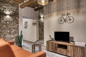 a living room with a tv and a bike on the wall at Il Nido nel Chianti in Greve in Chianti