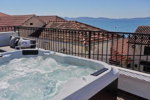a hot tub on top of a balcony with water at Villa Vito in Bibinje