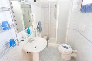 Baño blanco con lavabo y aseo en Villa La Cavaliera, en San Vincenzo
