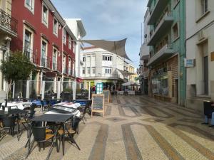 une rue vide avec des tables, des chaises et des bâtiments dans l'établissement Rooms_Heart Apartment, à Faro