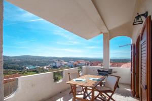 a patio with a table and chairs on a balcony at Quadrilocale Laura in Santa Teresa Gallura