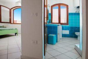 a blue bathroom with a toilet and a sink at Quadrilocale Laura in Santa Teresa Gallura