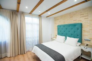 a bedroom with a large bed and a brick wall at Acetres 5 in Seville