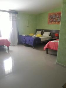 ein Zimmer mit 2 Betten und einem Sofa darin in der Unterkunft Vivenda Viviani in Praia