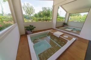 a large bathroom with a hot tub and two windows at Centro Vacanze Camping Spinnaker in Marina Palmense