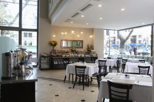 um restaurante com mesas e cadeiras brancas e um balcão em MR Hotel Providencia (ex Hotel Neruda) em Santiago