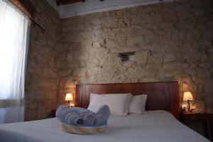 una camera con un letto e un muro in pietra di Drommire In Plassa E Clesia a Baunei