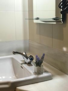 un lavabo con una flor en un recipiente. en Corrillo Suite Plaza Mayor - Parking opcional, en Salamanca 23 fotos más