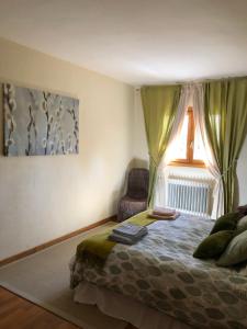 a bedroom with a bed with a window and a chair at Casa Marian Villanua in Villanúa