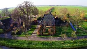 una vista aérea de una casa en un campo en De Heerlijkheid Ruinerwold, en Ruinerwold