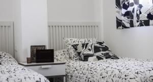 een slaapkamer met 2 bedden en een laptop op een tafel bij Apartamento El Hechizo Alto in Albacete