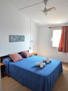 1 dormitorio con 1 cama azul y 2 toallas en Nure Mar y Mar, en Cala en Blanes