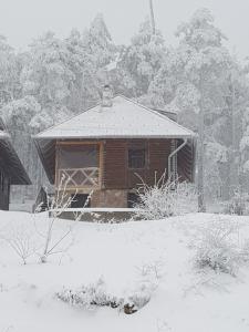 ein schneebedecktes Haus vor der Tür in der Unterkunft Divcibarski Konak in Divčibare