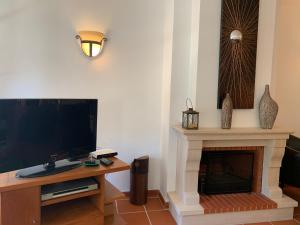 Il comprend un salon doté d'une cheminée et d'une télévision à écran plat. dans l'établissement T2 Portucale Apartment, à Casal da Lagoa Seca