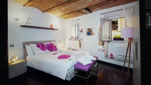 a bedroom with a white bed and a purple chair at Domus Paradiso in Rome