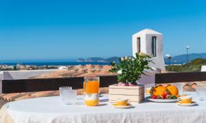 una mesa con fruta y zumo de naranja en el balcón en GREEN HILL BeB, en Alghero