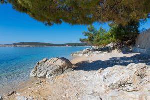 a beach with some rocks and the water at Villa St Martin-Reef - Exclusive Seafront Villa with Private Heated Pool in Martinšćica