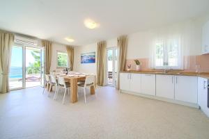 a kitchen and dining room with a table and chairs at Villa St. Martin-Reef in Martinšćica