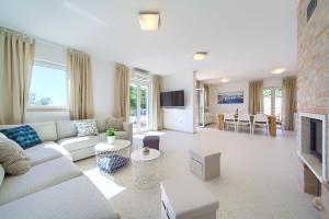 a living room with a couch and a tv at Villa St Martin-Reef - Exclusive Seafront Villa with Private Heated Pool in Martinšćica +37 photos
