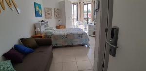 ein Wohnzimmer mit einem Sofa und einem Bett in der Unterkunft Condado Aldeia dos Reis 114 e 213 in Mangaratiba